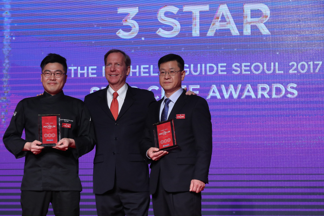 International director of the Michelin Guides Michael Ellis (center) poses with Korea‘s Michelin three-star chefs, Lee Byeong-jin of Gaon (left) and Kim Sung-il of La Yeon, at the Michelin Guide Seoul launch event held at The Shilla Seoul on Monday. (Yonhap)