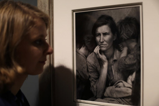 A Tate member of staff poses next to American photographer Dorothea Lange’s “Migrant Mother,” from 1936, at the press preview of “The Radical Eye: Modernist Photography from the Sir Elton John Collection” exhibition at the Tate Modern gallery in London, Tuesday. (AP-Yonhap)