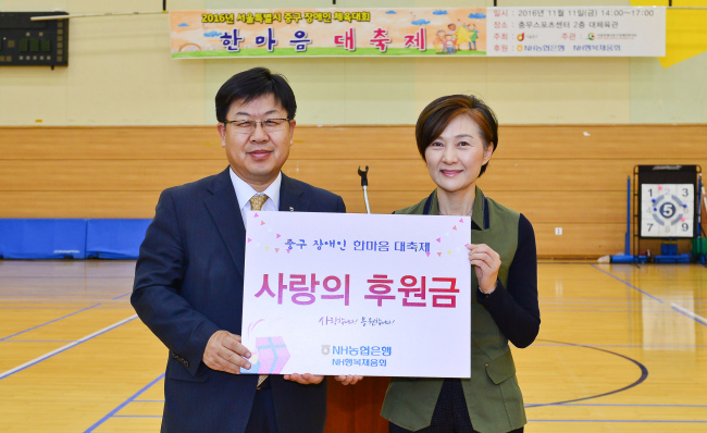 NH농협은행 이경섭 은행장(왼쪽)이 서울 중구장애인복지관 정진옥 관장에게 후원금을 전달하고 있다.
사진=NH농협은행 제공