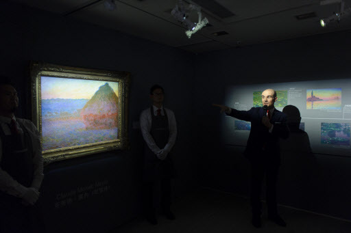 Conor Jordan, deputy chairman of impressionist and modern art at Christie’s, points to details in a painting by Claude Monet entitled “Meule” as he addresses guests during an auction preview in Hong Kong on Oct. 18. The artwork will be auctioned by Christie’s in New York on Wednesday. (AFP-Yonhap)