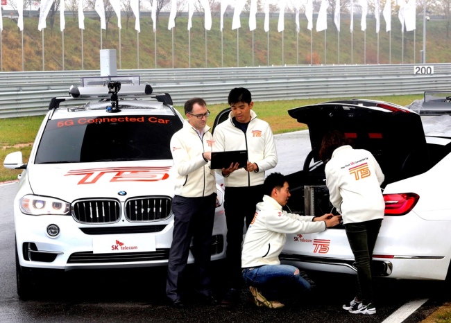 SK Telecom employees prepare the T9, a connected car running on a 5G trial network, for a test run at the BMW Driving Center in Incheon. SKT built the T9 by installing its 5G terminals in two BMW vehicles -- the new X5 and X7. (SK Telecom)