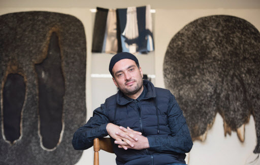 Syrian artist Ali Kaaf poses in front of his paper artwork Rift II (left) and Rift I at his studio in Neukoelln district on Oct. 4 in Berlin. (AFP-Yonhap)
