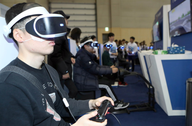 Visitors try out games on Sony's Playstation VR at G-Star 2016 (Yonhap)