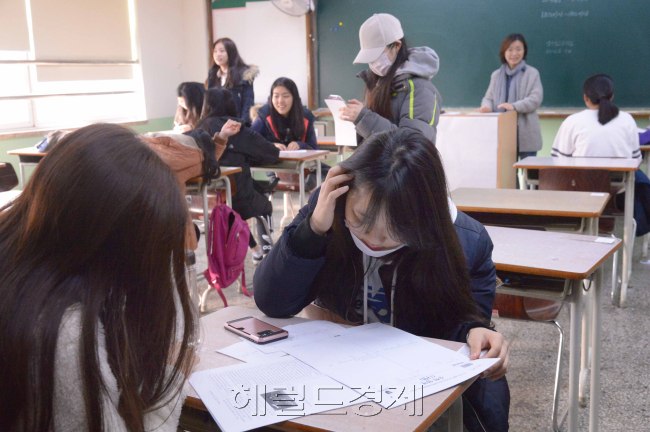 [사진=지난 17일 2017학년도 대학수학능력시험을 치른 서울 강남구 압구정고 3학년 학생들이 18일 오전 등교, 삼삼오오 모여 수능 가채점을 하며 자신의 진로에 대해 고민하고 있다. 입시업체들은 올해 수능의 경우 수학 나형의 1등급 컷(원점수 기준)이 무려 7점이나 떨어지는 등 영역 전반에 걸쳐 어렵게 출제된 것으로 분석했다. 정희조 기자 / checho@heraldcorp.com]