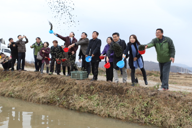 Residents and officials throw food for migratory birds at a field, as part of a program hosted at the DMZ Peace Town for Migratory Birds in Cheorwon, Gangwon Province. (Cheorwon County)
