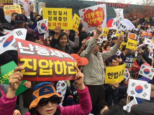 People participating in a pro-Park rally hold signs reading "I love Park Geun-hye" in front of Seoul Station in central Seoul Saturday. (Ock Hyun-ju/The Korea Herald)