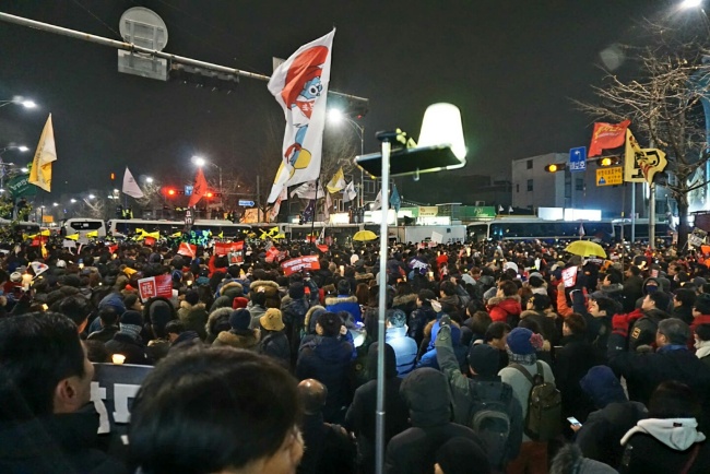 [사진=제5차 대규모 촛불집회에 참가한 시민들이 지난 26일 서울 종로구 통의동에서 경찰의 차벽에 가로막혀 경찰병력과 대치하고 있다. 경찰 측은 집시법 조항에 근거에 오후 5시 이후 청와대 방향으로의 집회 및 행진을 금지했다.]