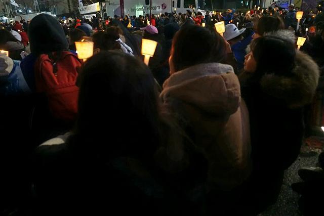 지난 26일 저녁 서울 광화문광장에서 열린 촛불문화제에서 10대 청소년들이 촛불을 들고 가수의 공연에 환호하고 있다.