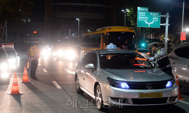 [사진설명=1일 새벽 서울 송파구 방이삼거리에서 경찰이 음주운전 불시 단속을 펼치고 있다. 연말연시를 맞아 각종 술자리가 많아지면서 자칫 증가할 수 있는 음주운전, 그 중에서도 숙취운전에 대비하기 위한 조처다. 경찰 관계자는 “단속만으로 음주운전을 근절하는 데는 한계가 있다”며 “음주운전이 의심되는 차량은 신고하고 지인이 음주운전을 하려는 경우 적극 만류해 달라”고 당부했다. 박현구 기자 phko@heraldcorp.com]
