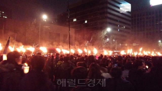 촛불이 횃불이 됐다. 박근혜 대통령을 향한 표현은 거칠어졌다. 탄핵을 반대하는 새누리당 현수막은 갈기갈기 찢어지고 계란 세례를 맞았다. 그러나 분노한 민심은 마지막 자제력을 보였다. 사진은 주말 집회 모습. [공동취재단]