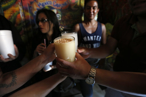Glasses filled with pulque are delivered to a customer at Las Duelistas pulqueria, in Mexico City, Saturday. (AP-Yonhap)