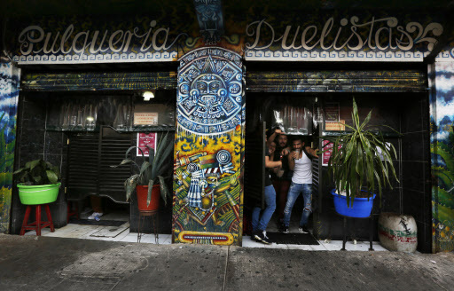Patrons stand in a doorway of Las Duelistas pulqueria, in Mexico City, on Dec. 3. (AP-Yonhap)