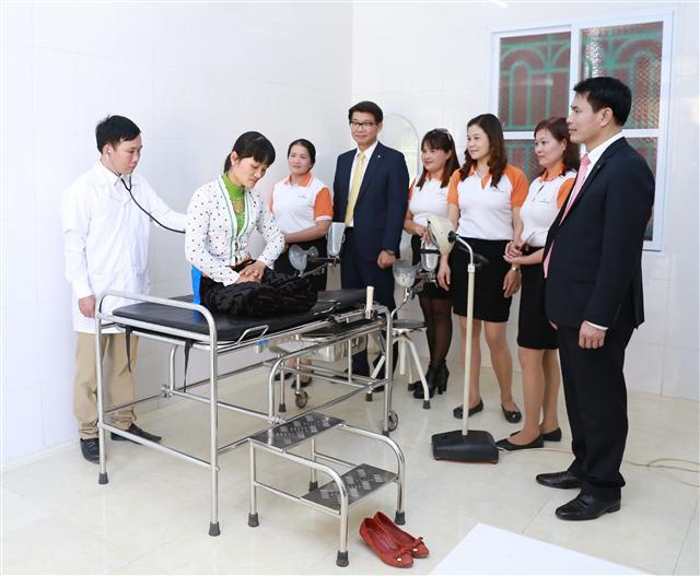 한화생명 백종국 베트남법인장(왼쪽서 네번째)이 설계사들과 함께 보건소 개소 후 첫번째 환자의 진료를 지켜보고 있다.
