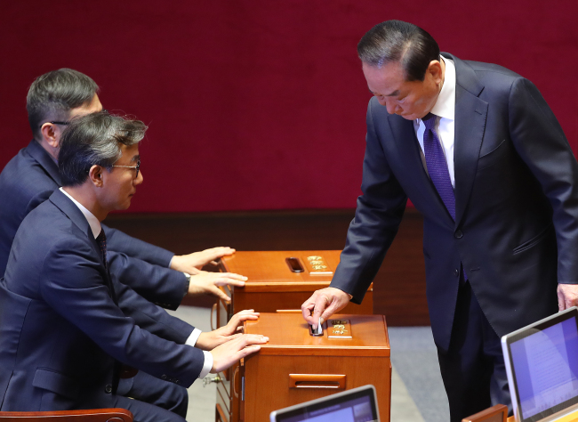 Rep. Suh Chung-won (right) of the Saenuri Party participates in Friday's impeachment vote on President Park Geun-hye at the National Assembly. (Yonhap)