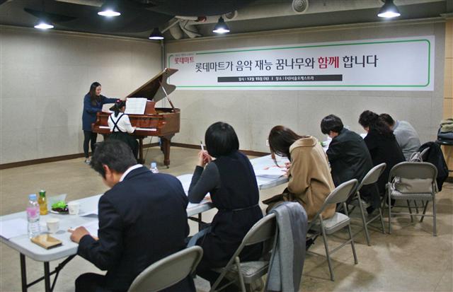 한 지원자가 오디션장에서 피아노를 연주하는 가운데 심사위원들이 심사를 하고 있다.
[사진제공=롯데마트]