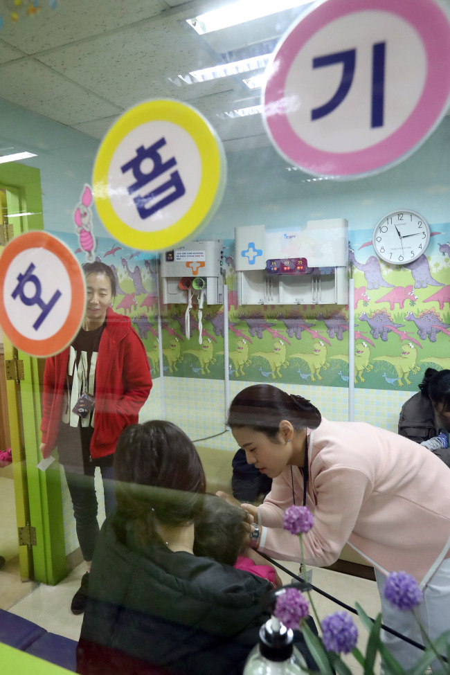 A nurse examines a child at a pediatrics clinic in Seoul on Friday. (Yonhap)