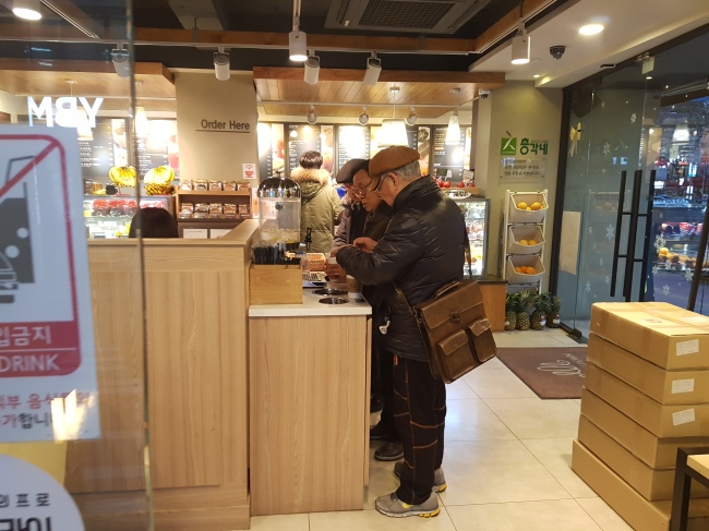 [사진설명=탑골공원 인근의 저가형 커피숍에서 노인들이 커피에 시럽을 뿌리고 있는 모습.]