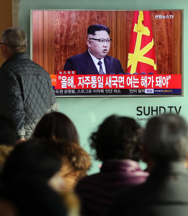 South Korean citizens on Sunday watch North Korean leader Kim Jong-un make a speech on TV at Seoul Station. (Yonhap)