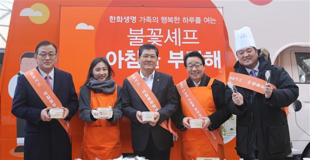 한화생명 차남규(가운데) 사장과 윤병철 영업총괄 부사장 및 임직원들이 ‘불꽃셰프, 아침을 부탁해’ 첫날 행사에서 직접 요리한 컵밥을 들어보이고 있다.