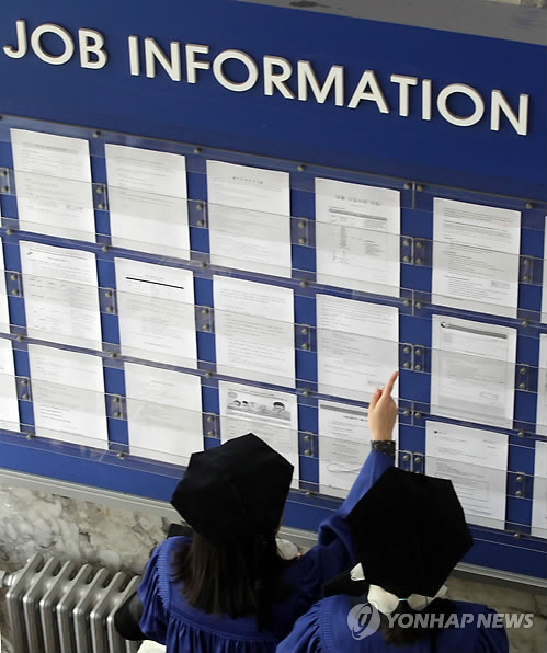 Graduates view a bulletin on job offers after attending a commencement ceremony at a university in Seoul(Yonhap)