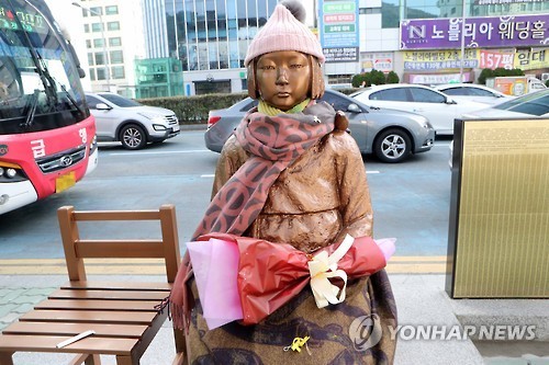 A statue of a girl symbolizing former Korean sex slaves for Japanese soldiers during World War II is seen wearing a scarf and a woolen hat in front of the Japanese Consulate in the southern South Korean port city of Busan on Jan. 7, 2017. South Korea expressed "strong regret" over Japan's decision to recall its top envoy in Seoul and its consul general in Busan in protest of the erection of the statue by a civic group late last month. (Yonhap)