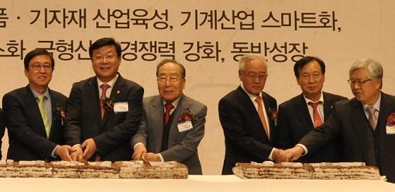 기계업계 신년인사회에서 기계진흥회 정지택 회장(왼쪽부터), 산업통상자원부 주형환 장관, KC코트렐 이달우 회장, 신성솔라에너지 이완근 회장, 인아그룹 신계철 회장, 화천기계 권영렬 회장 등이 축하떡을 자르고 있다
