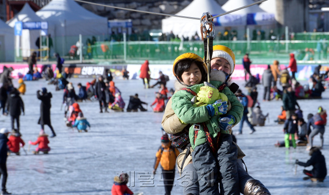 [사진설명=길이 500m에 달하는 짐라인 기구인 하늘가르기를 탄 관광객이 얼음낚시터 상공을 가로지르며 짜릿한 스릴를 맛보고 있다.]