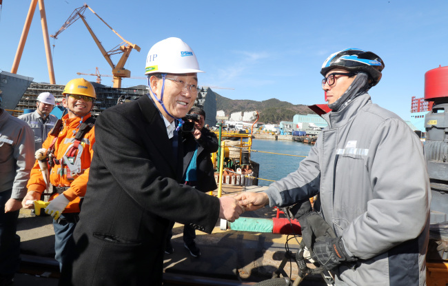 Former UN Secretary-General Bank Ki-moon holds hands with workers of Daewoo Shipbuilding and Marine Engineering at a shipyard in Geoje, South Gyeongsang Province on Monday (Yonhap)