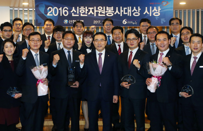 20일 서울 중구 소재 신한은행 본점에서 지난 한 해 동안 자원봉사활동에 적극적으로 참여한 부서 및 영업점 직원들을 격려하는 ‘2016 신한자원봉사대상’ 시상식이 진행됐다. 시상식 후 신한은행 조용병 은행장(앞줄 가운데)과 수상 부서 및 점포 직원들이 기념촬영하는 모습. [사진제공=신한은행]
20일 서울 중구 소재 신한은행 본점에서 지난 한 해 동안 자원봉사활동에 적극적으로 참여한 부서 및 영업점 직원들을 격려하는 ‘2016 신한자원봉사대상’ 시상식이 진행됐다. 시상식 후 신한은행 조용병 은행장(앞줄 가운데)과 수상 부서 및 점포 직원들이 기념촬영하는 모습. [사진제공=신한은행]