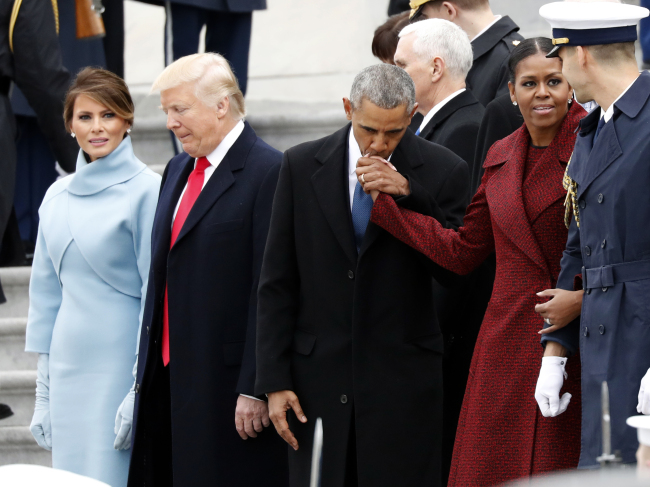 First lady Melania Trump stands with President Donald Trump as former President Barack Obama kisses the hand of his wife Michelle Obama, during a departure ceremony on the East Front of the U.S. Capitol, Jan. 20, 2017 in Washington. (AP Photo/Alex Brandon)