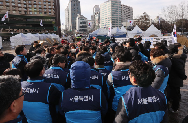 Officials of Seoul Metropolitan Government clash with supporters of President Park Geun-hye over a makeshift protest camp illegally installed in front of the City Hall building on Tuesday (Yonhap)