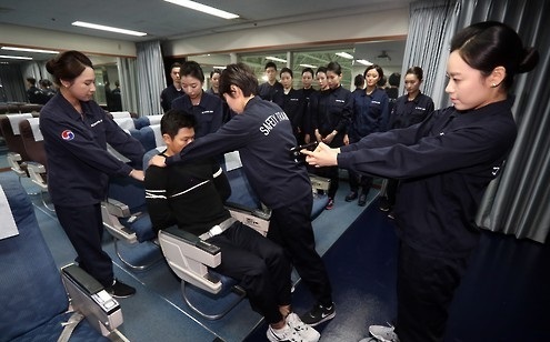 Korean Air flight attendants learn to use taser guns and ropes in  a safety protocols training facility at the airport (Yonhap)