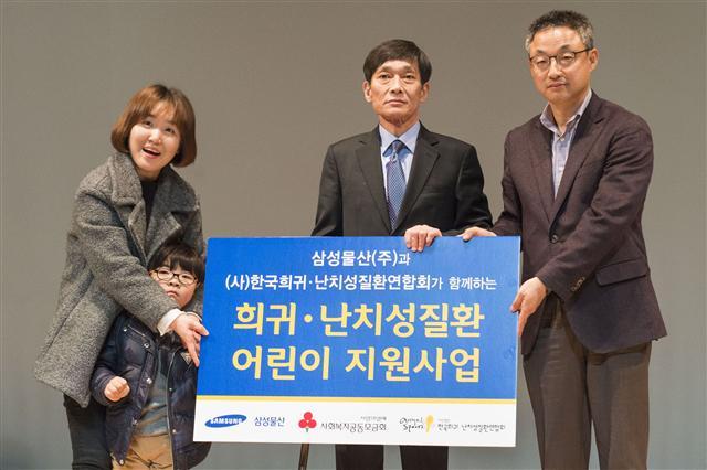삼성물산 리조트부문 사회공헌담당 문지태 상무(사진 오른쪽)와 한국 희귀ㆍ난치성질환연합회 신현민 회장(가운데), 지원 대상자로 선정된 어린이가 포즈를 취하고 있다.