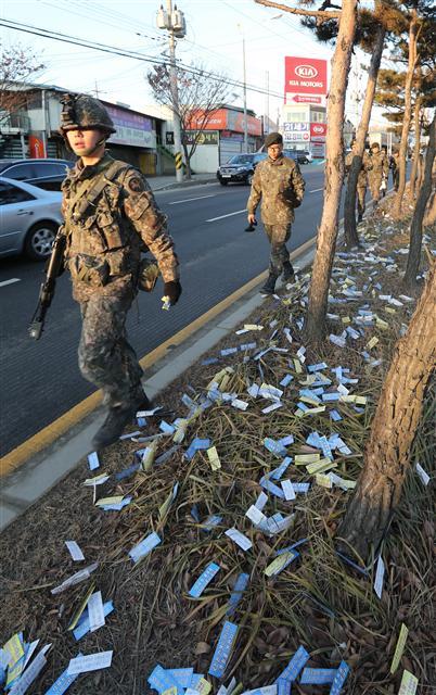 9일 오전 경기도 고양시 일산동구 풍동 육군 9사단 정문 인근 도로에 박 대통령과 다음 달 시행하는 한미연합훈련을 비난하는 내용 등이 담긴 전단 2만장이 떨어져 장병들이 수거에 나섰다. [연합뉴스]