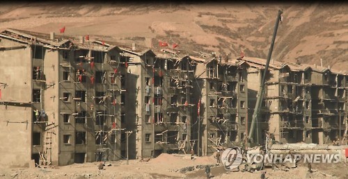 North Korean construction workers repair houses from flood damages. (Yonhap)