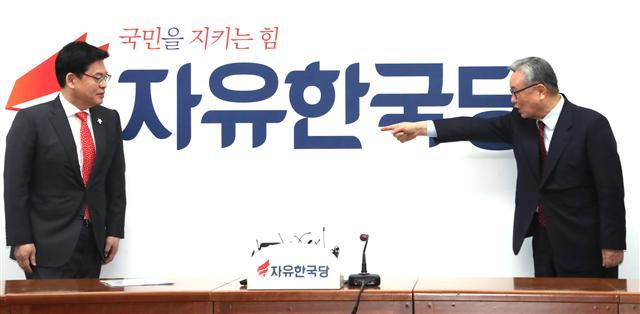 자유한국당 인명진(오른쪽) 비상대책위원장과 정우택 원내대표가 14일 오전 서울 여의도 당사에서 열린 비상대책위원회의에서 전날 확정된 새 당명과 로고가 찍힌배경막을 보며 얘기를 나누고 있다.  [연합뉴스]