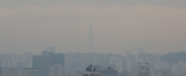 Fine dust covers the cityscape of Jongno-gu and Lotte World Tower in Jamsil, Seoul, on Thursday. (Yonhap)