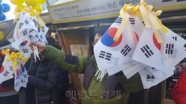 지난 18일 서울 종로구 광화문광장 일대에서 열린 제16차 촛불집회에서는 노란 리본을 부착한 태극기를 들고 집회에 참가한 사람들의 모습을 어렵지 않게 찾아볼 수 있었다.  [헤럴드경제DB]