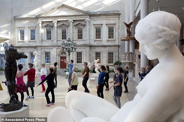 An exercise group stretches amongst ancient statues in the American wing at the Metropolitan Museum of Art in New York on Feb. 10. (AP-Yonhap)