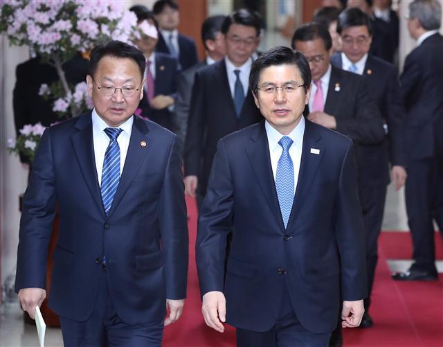 <YONHAP PHOTO-1318> 국무회의 입장하는 황 권한대행 (서울=연합뉴스) 이상학 기자 = 황교안 대통령 권한대행 국무총리(오른쪽)와 유일호 경제부총리가 21일 오전 세종로 정부 서울청사에서 열린 서울-세종청사 간 영상국무회의에 참석하고 있다. 2017.2.21 leesh@yna.co.kr/2017-02-21 09:01:21/ <저작권자 ⓒ 1980-2017 ㈜연합뉴스. 무단 전재 재배포 금지.>