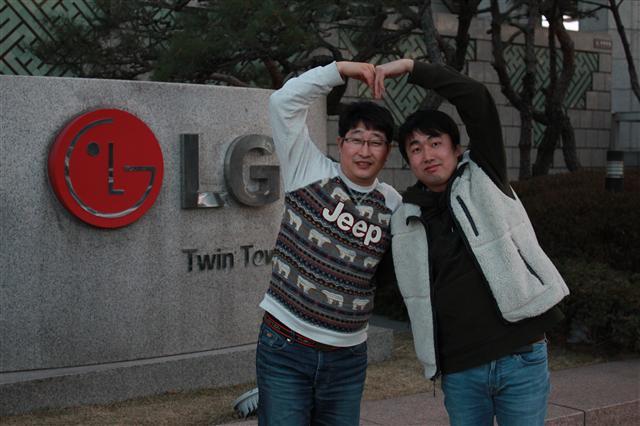 LG디스플레이 구미 공장에서 기장으로 재직중인 진원우씨(왼쪽)와 파주 공장에서 재직중인 김덕찬씨(오른쪽)가 여의도 LG트윈타워 앞에서 ‘사랑해요’ 포즈를 취하고 있다.