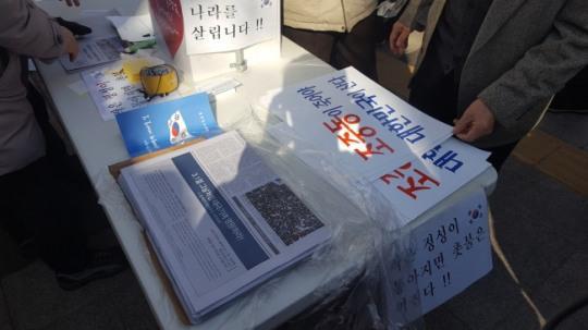 가짜뉴스라고 불리는 매체들이 시민들의 도움으로 ‘가짜뉴스’를 양산하는데 힘쓰고 있다. 한 집회 참가자가 지난 18일 서울시청 앞에서 열린 탄핵반대집회에서 가짜뉴스라고 일컬어지는 인쇄물을 배포하고 있는 모습.