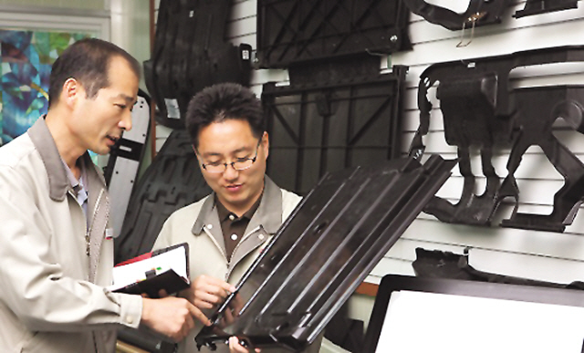 LG하우시스 울산공장 직원들이 강철(Steel) 소재 대비 무게를 30% 가량 줄일 수 있는 경량화 소재를 적용한 자동차 언더커버 제품을 검사하고 있다