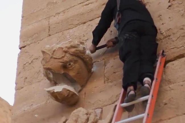 A militant hammers away at a face on a wall in Hatra, a large fortified city recognized as a UNESCO World Heritage site, 110 kilometers southwest of Mosul, Iraq, in this file image made from a militant video posted on YouTube on April 3, 2015, which has been verified and is consistent with other AP reporting. (AP-Yonhap)
