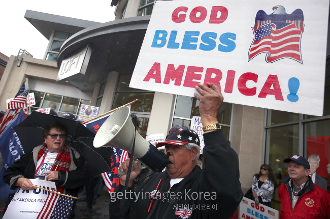 27일(현지시간) 미국 캘리포니아주 브레아에서 트럼프 지지자들이 미국 국기를 들고 “미국이 우선(America First)”이라는 구호를 외치고 있다.[출처=게티이미지]