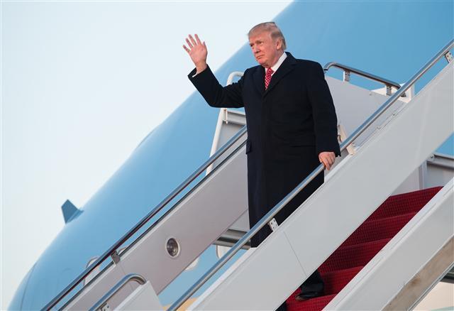 <YONHAP PHOTO-0829> US President Donald Trump waves as he steps off Air Force One at Andrews Air Force Base in Maryland, on March 5, 2017. / AFP PHOTO / NICHOLAS KAMM/2017-03-06 08:32:15/ <저작권자 ⓒ 1980-2017 ㈜연합뉴스. 무단 전재 재배포 금지.>