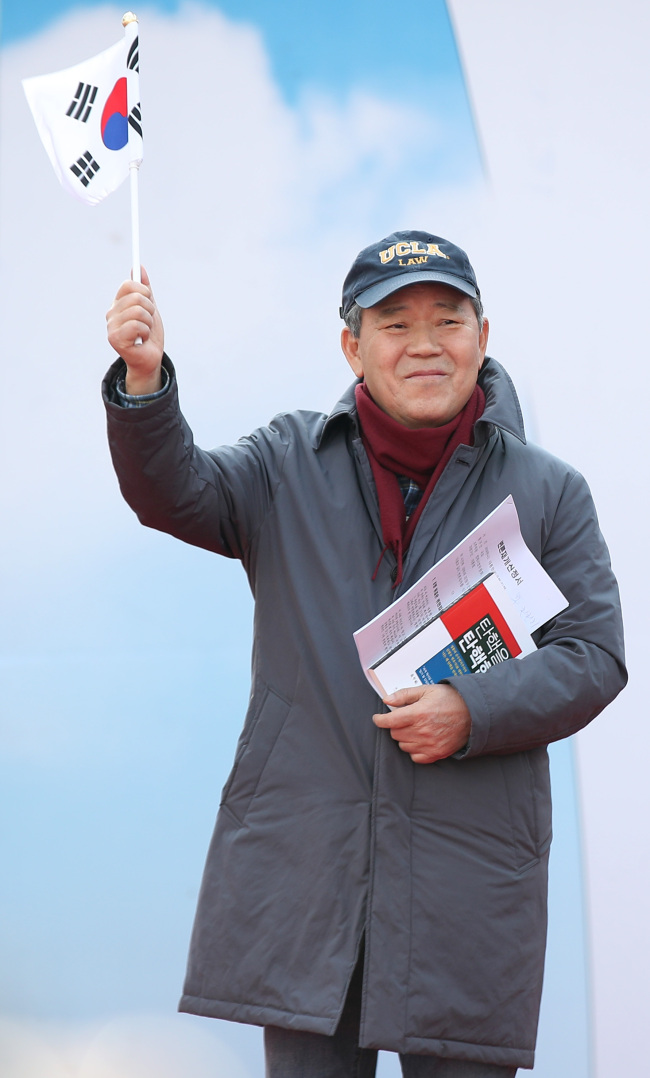 Kim Pyung-woo, legal representative for President Park Geun-hye, stands at the podium before Park supporters on Saturday (Yonhap)