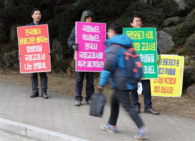 7일 오전 경북 경산시 백천동 문명고등학교 정문 앞에서 학교 인근 주민들이 국정교과서 채택에 반대하는 내용의 피켓을 들고 있다. [연합뉴스]