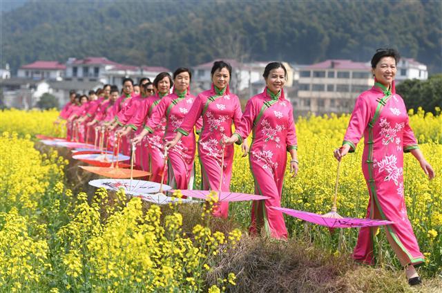 <YONHAP PHOTO-5385> (170308) -- NANCHANG, March 8, 2017 (Xinhua) -- Women present Qipao, a traditional Chinese dress, during a Qipao show at a cole flower field in Nanchang, capital of east China's Jiangxi Province, March 8, 2017. (Xinhua/Wan Xiang) (zyd)/2017-03-08 21:07:49/ <저작권자 ⓒ 1980-2017 ㈜연합뉴스. 무단 전재 재배포 금지.>