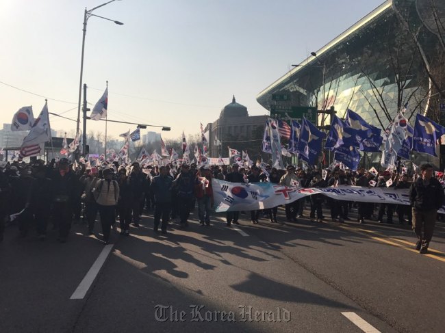 Pro-Park protestors stage a parade toward the Namdaemun gate from Seoul Plaza on Saturday. (Bak Se-hwan/The Korea Herald)